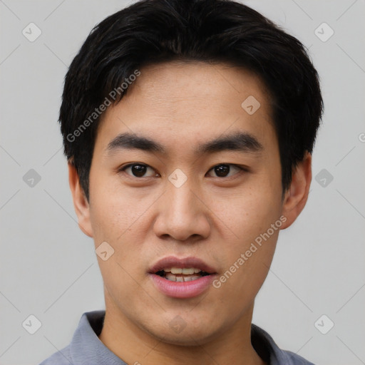 Joyful asian young-adult male with short  black hair and brown eyes