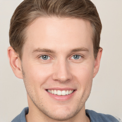 Joyful white young-adult male with short  brown hair and grey eyes