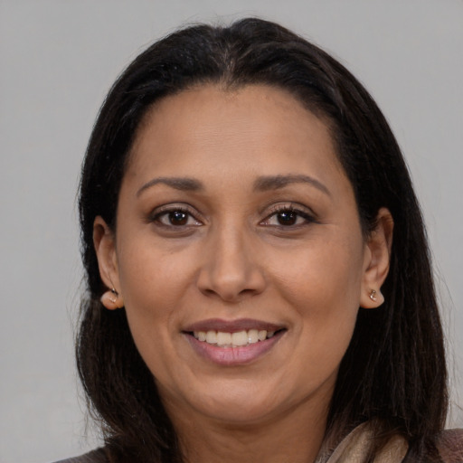 Joyful latino adult female with long  brown hair and brown eyes