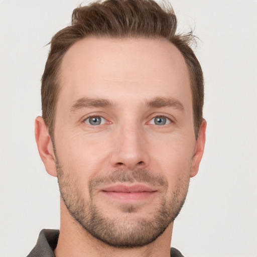 Joyful white young-adult male with short  brown hair and grey eyes