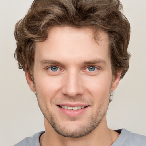 Joyful white young-adult male with short  brown hair and grey eyes