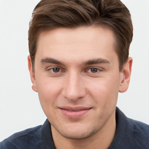 Joyful white young-adult male with short  brown hair and grey eyes