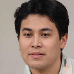 Joyful latino young-adult male with short  brown hair and brown eyes