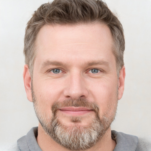 Joyful white adult male with short  brown hair and grey eyes