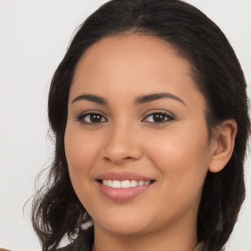 Joyful latino young-adult female with long  brown hair and brown eyes