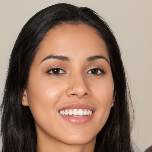 Joyful latino young-adult female with long  brown hair and brown eyes