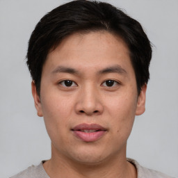 Joyful asian young-adult male with short  brown hair and brown eyes