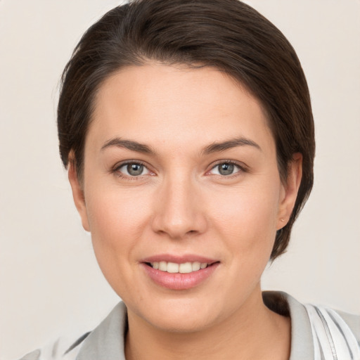 Joyful white young-adult female with short  brown hair and grey eyes