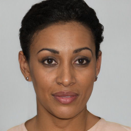 Joyful black young-adult female with short  black hair and brown eyes