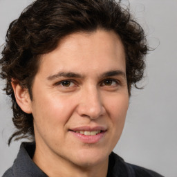 Joyful white adult male with medium  brown hair and brown eyes