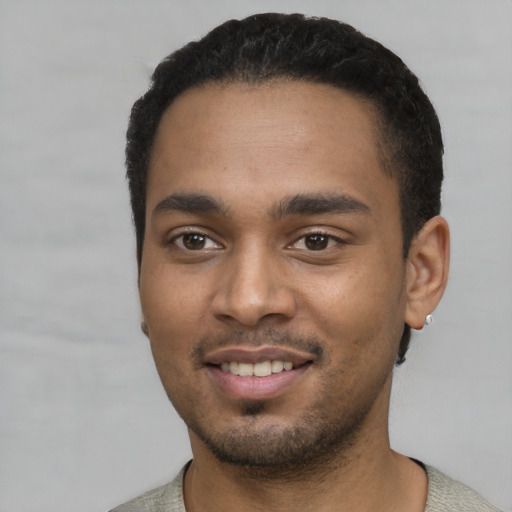 Joyful black young-adult male with short  black hair and brown eyes