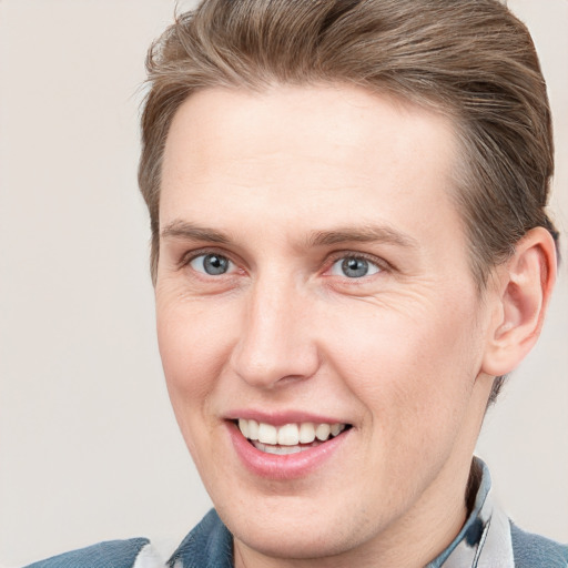 Joyful white young-adult male with short  brown hair and blue eyes