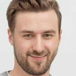 Joyful white young-adult male with short  brown hair and grey eyes