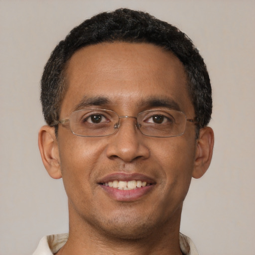 Joyful black young-adult male with short  brown hair and brown eyes