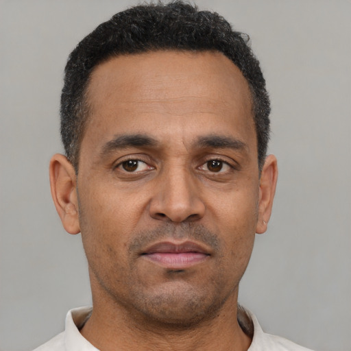 Neutral latino adult male with short  black hair and brown eyes