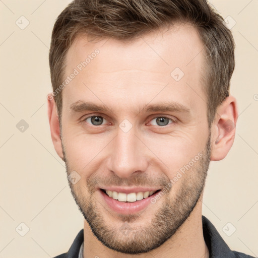 Joyful white young-adult male with short  brown hair and grey eyes