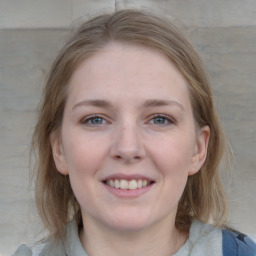 Joyful white young-adult female with medium  brown hair and blue eyes