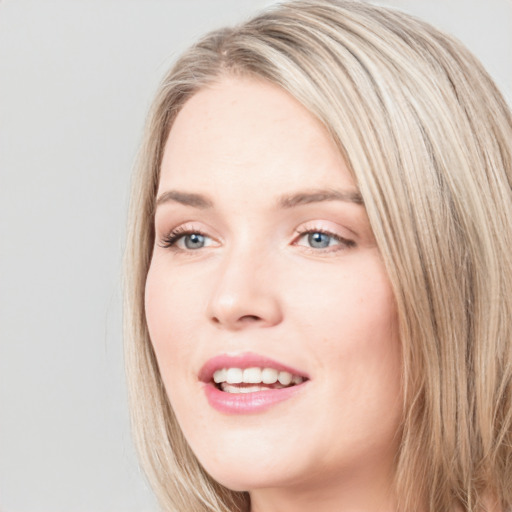 Joyful white young-adult female with long  brown hair and blue eyes