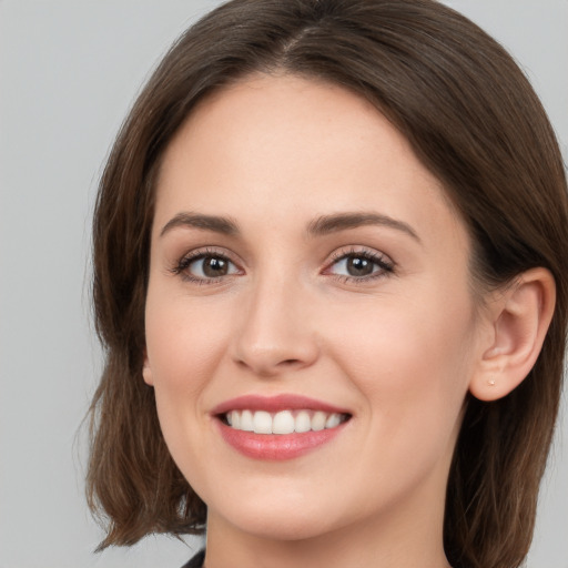 Joyful white young-adult female with medium  brown hair and green eyes