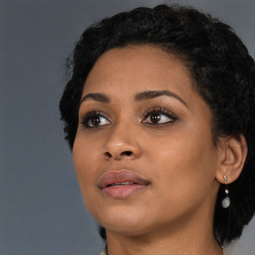 Joyful latino young-adult female with short  black hair and brown eyes