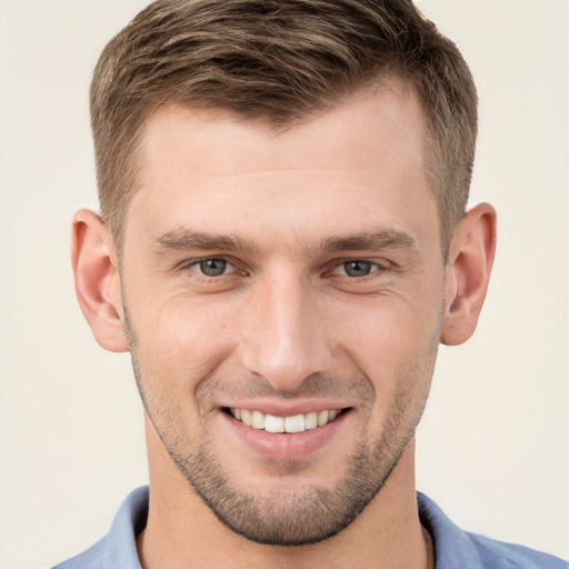 Joyful white young-adult male with short  brown hair and grey eyes