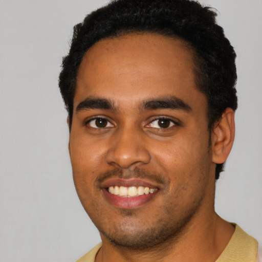 Joyful black young-adult male with short  black hair and brown eyes