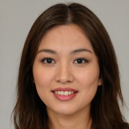 Joyful asian young-adult female with long  brown hair and brown eyes