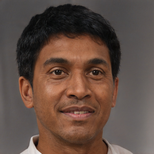Joyful black adult male with short  brown hair and brown eyes