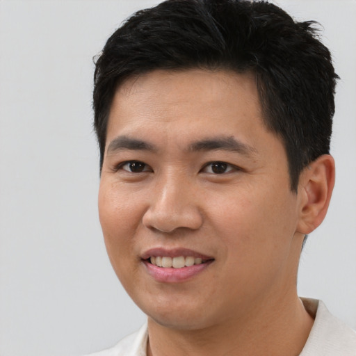 Joyful asian young-adult male with short  black hair and brown eyes