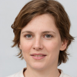 Joyful white young-adult female with medium  brown hair and green eyes