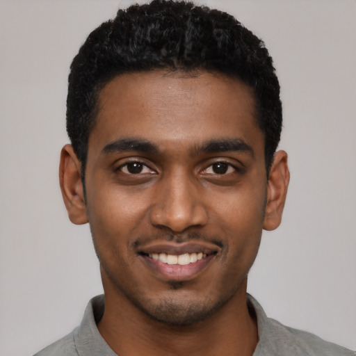 Joyful black young-adult male with short  black hair and brown eyes
