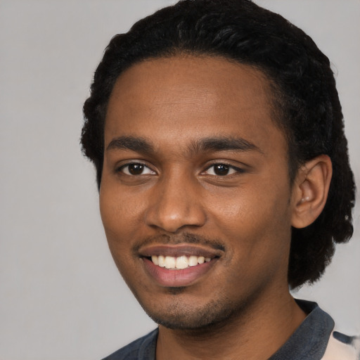 Joyful black young-adult male with short  black hair and brown eyes