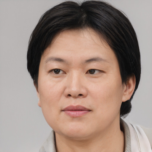 Joyful asian adult female with medium  brown hair and brown eyes