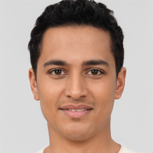 Joyful latino young-adult male with short  black hair and brown eyes