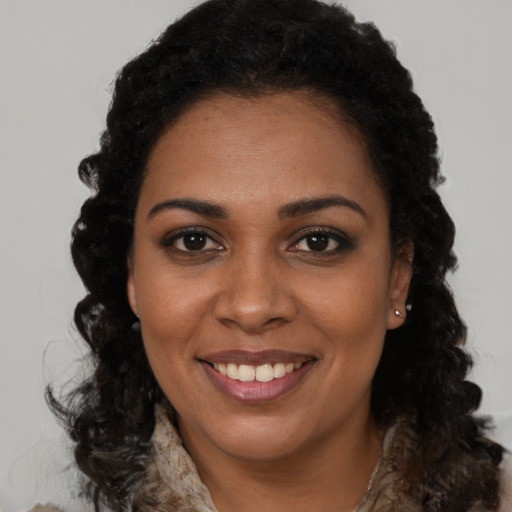 Joyful black young-adult female with long  brown hair and brown eyes