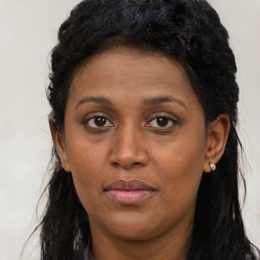 Joyful black adult female with long  brown hair and brown eyes