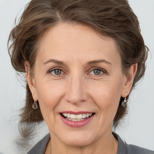 Joyful white adult female with medium  brown hair and brown eyes