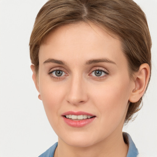 Joyful white young-adult female with medium  brown hair and grey eyes