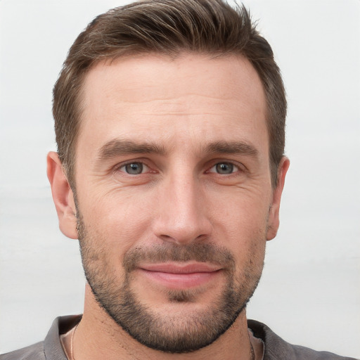 Joyful white young-adult male with short  brown hair and grey eyes