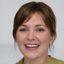 Joyful white young-adult female with medium  brown hair and blue eyes