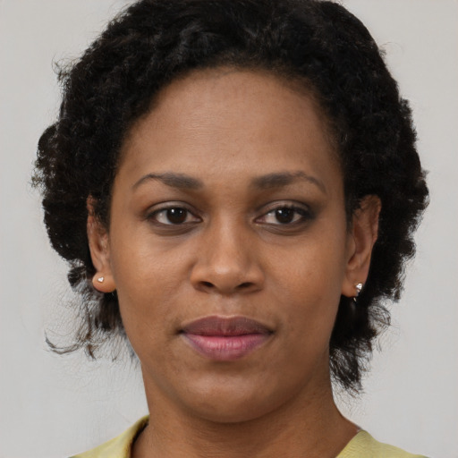 Joyful black adult female with short  black hair and brown eyes