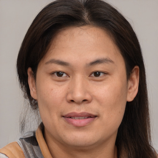 Joyful asian adult female with medium  brown hair and brown eyes