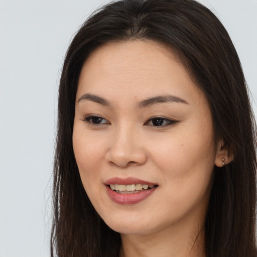 Joyful asian young-adult female with long  brown hair and brown eyes
