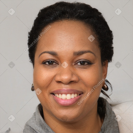 Joyful black adult female with short  black hair and brown eyes