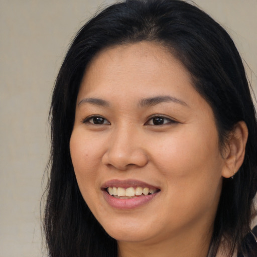 Joyful asian young-adult female with long  brown hair and brown eyes