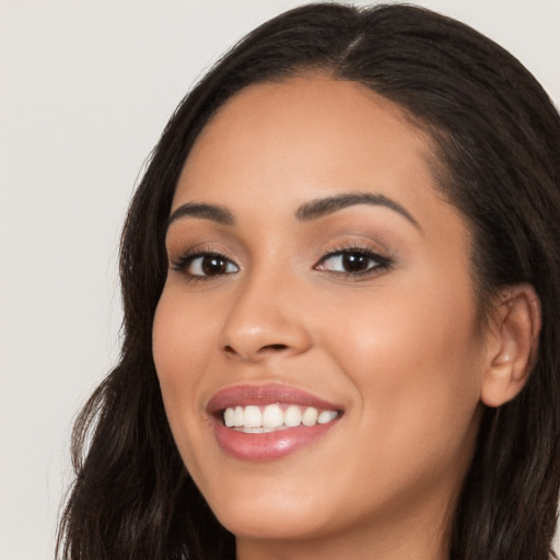 Joyful latino young-adult female with long  brown hair and brown eyes