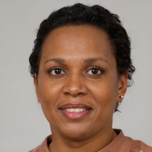 Joyful black adult female with short  brown hair and brown eyes