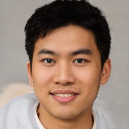 Joyful asian young-adult male with short  black hair and brown eyes