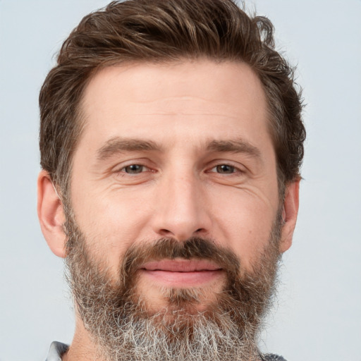 Joyful white adult male with short  brown hair and grey eyes