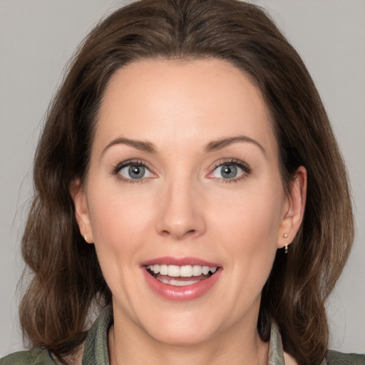 Joyful white young-adult female with medium  brown hair and green eyes